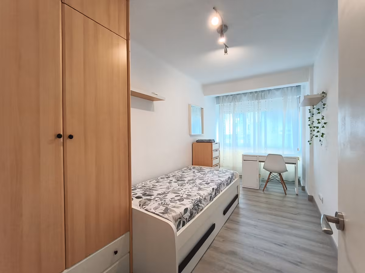 Habitación pequeña con cama de 90, escritorio y espejo en Santander